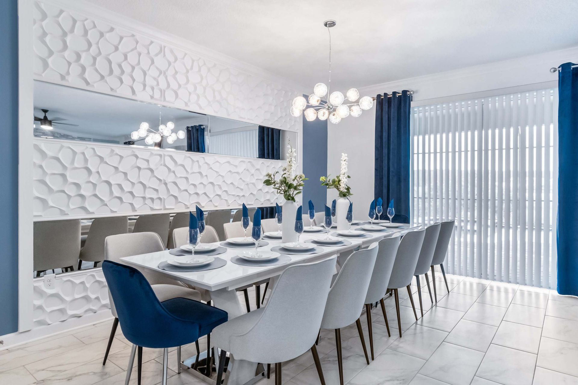 Elegant dining room with modern decor, blue accents, and seating for twelve guests

