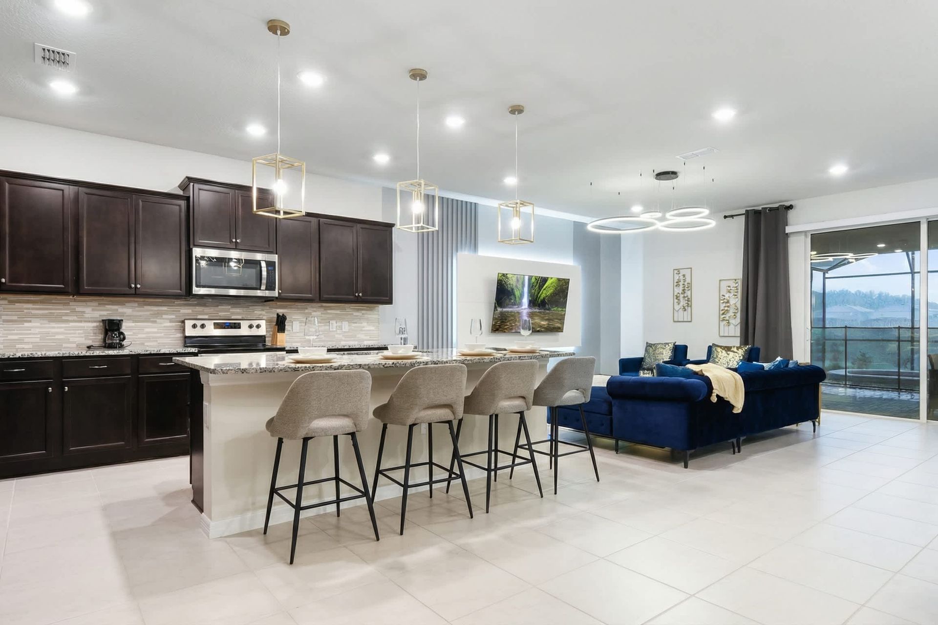 Stylish kitchen island and lounge area with sunset views and modern lighting.