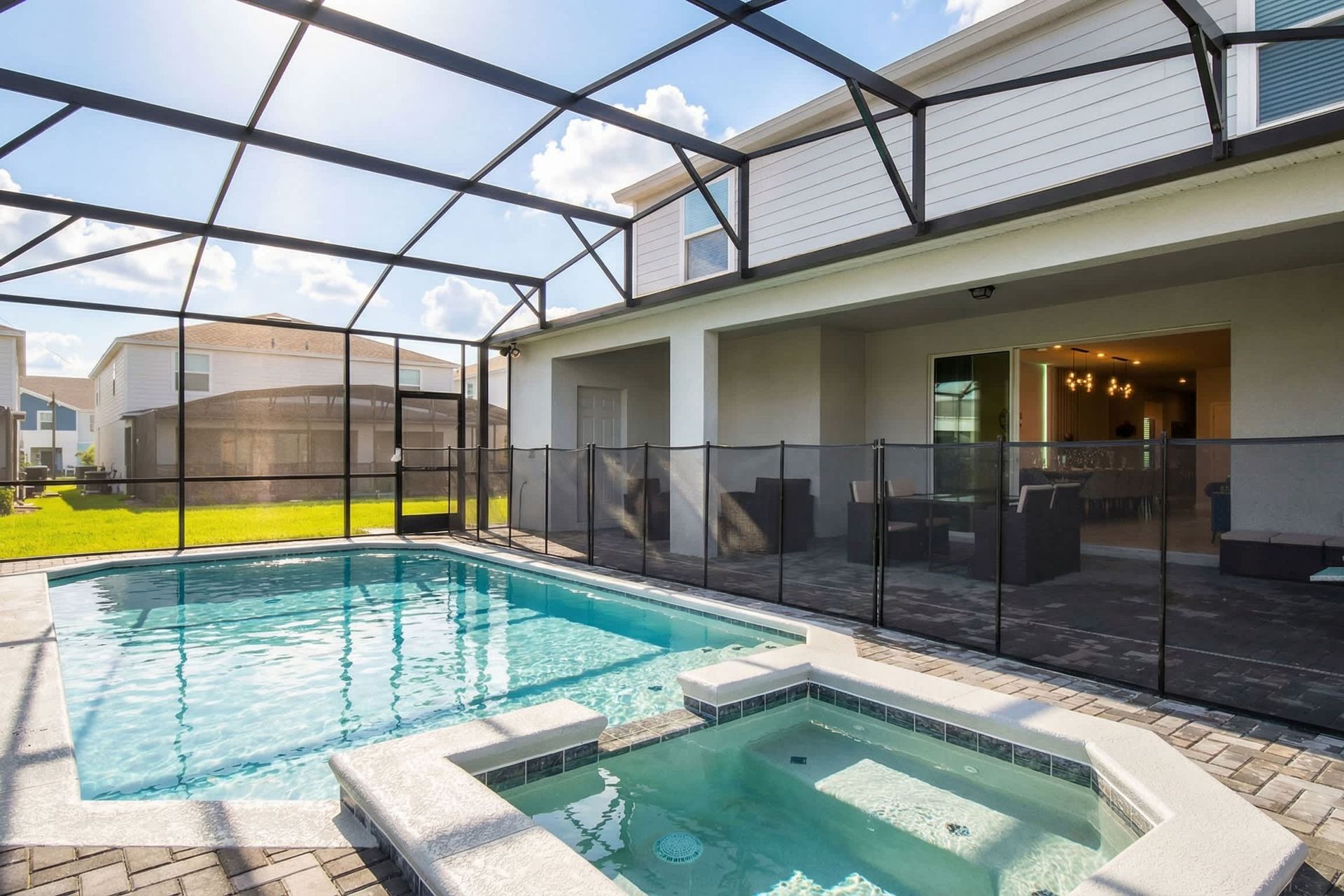 Relax in the private screened-in pool and spa with covered patio seating.