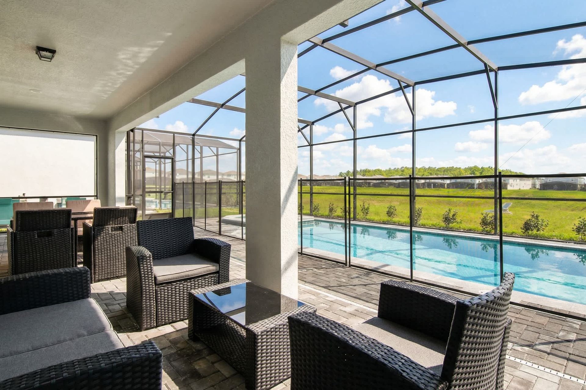 Covered patio with cozy seating and serene poolside views—perfect for unwinding.