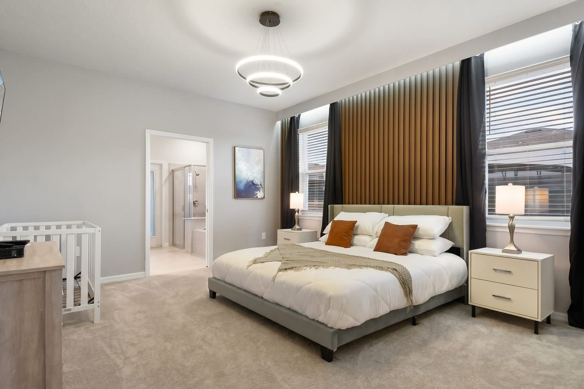 Modern primary suite with warm tones, elegant lighting, and an ensuite bathroom.