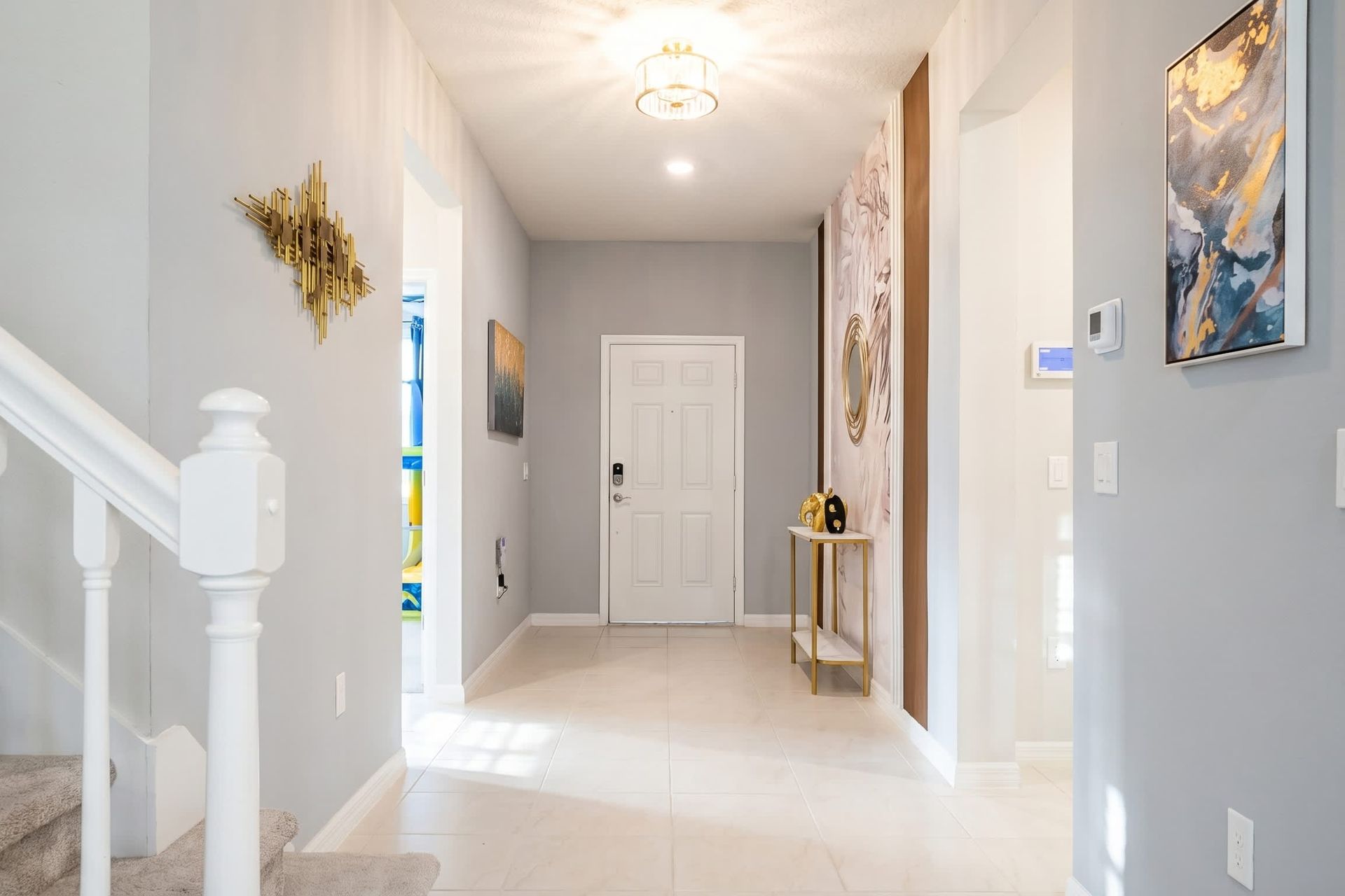 Bright and stylish entryway with modern art and sleek gold accents.

