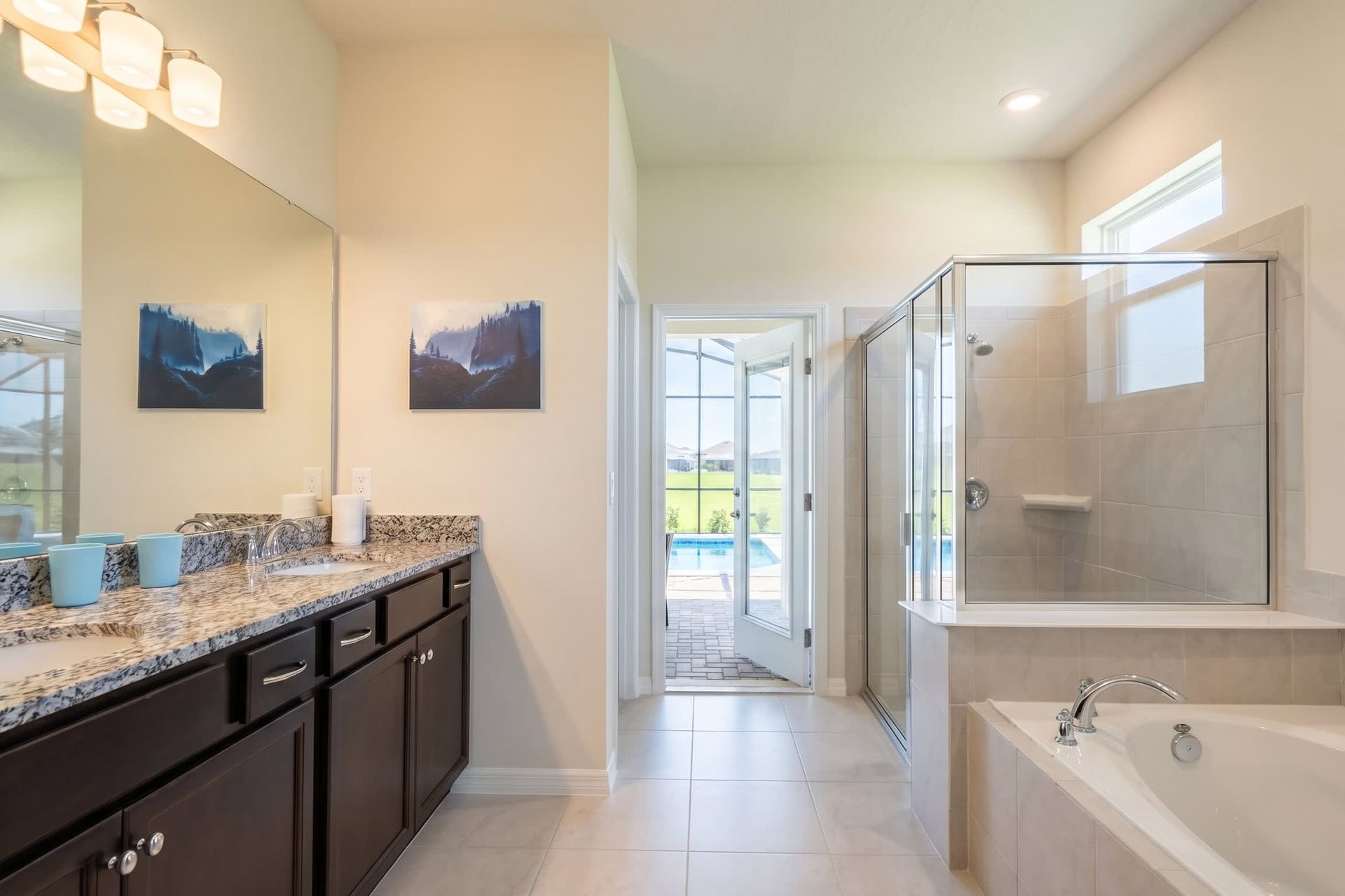 Spa-inspired bath with walk-in shower, dual vanities, and poolside access.