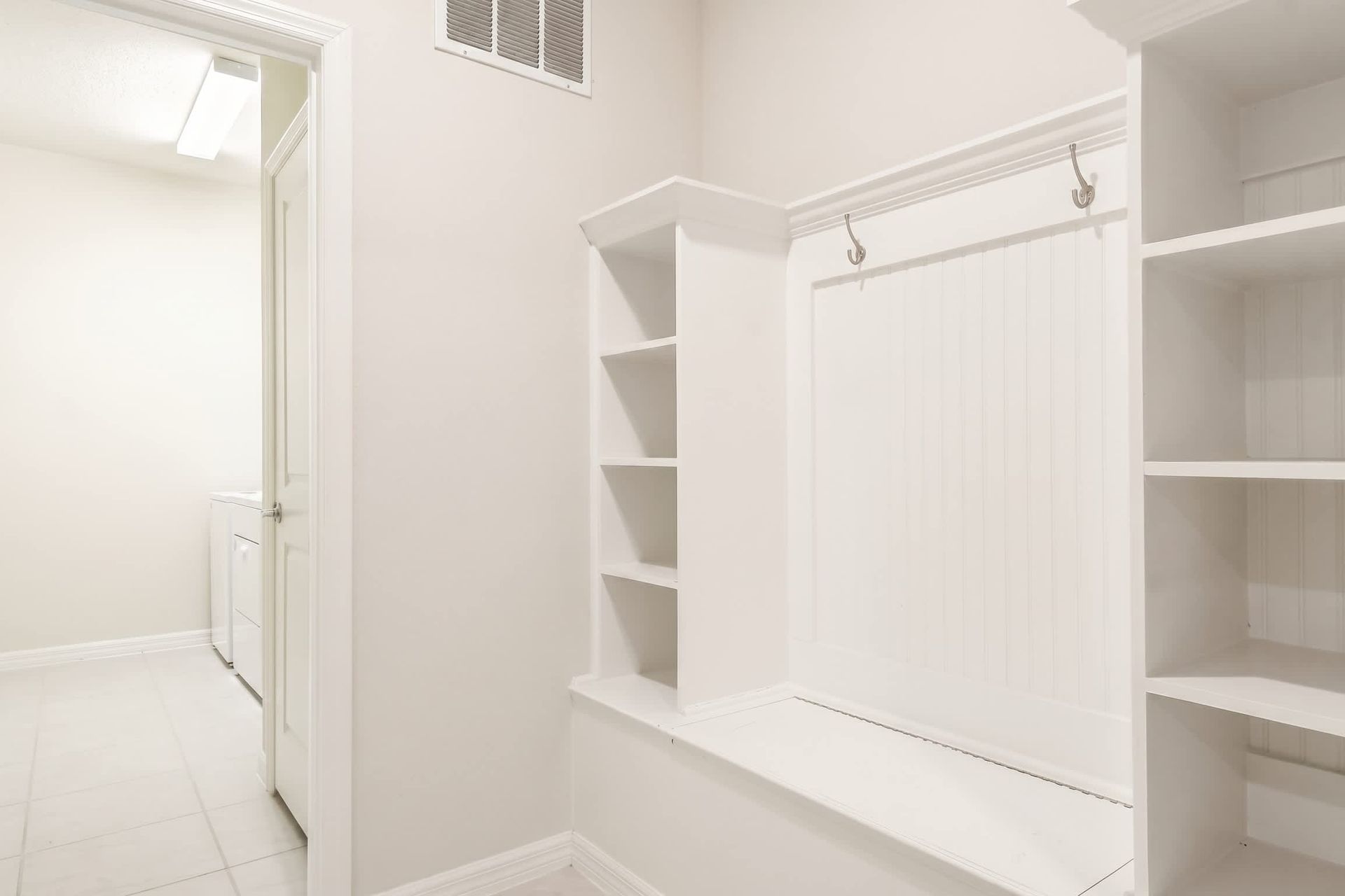 Spacious mudroom with built-in bench, cubbies, and direct laundry access.