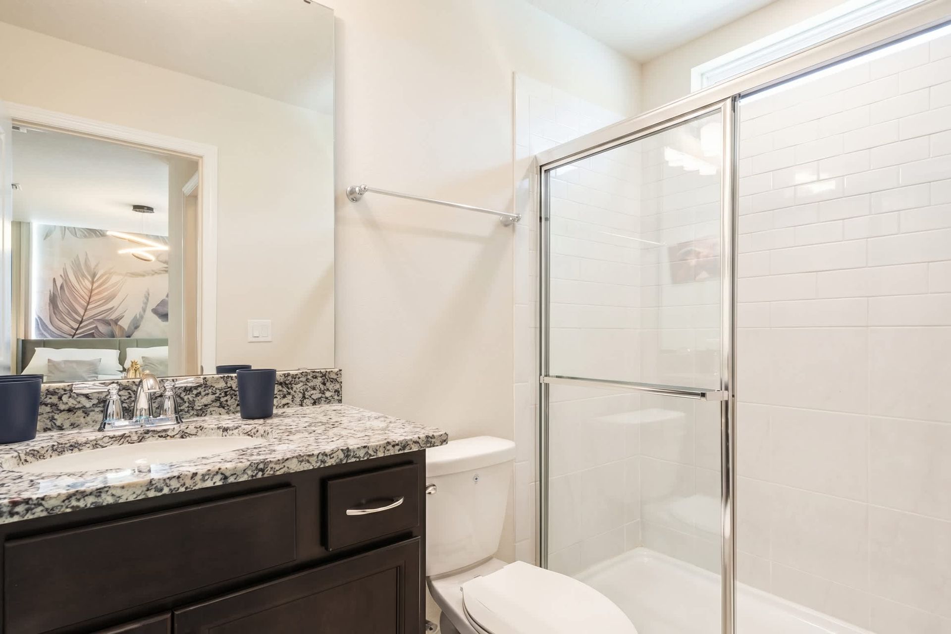 Stylish ensuite bath with granite counters and sleek walk-in glass shower.