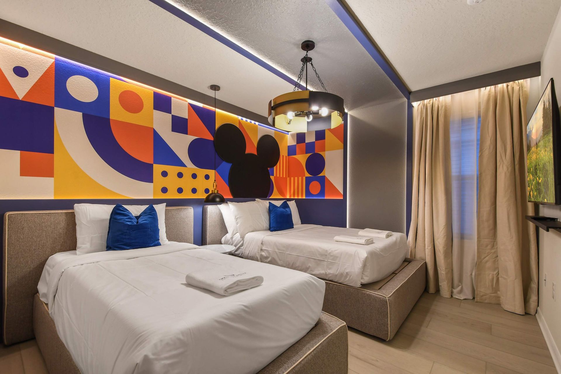 Playful Mickey-themed room with vibrant decor and cozy twin beds.