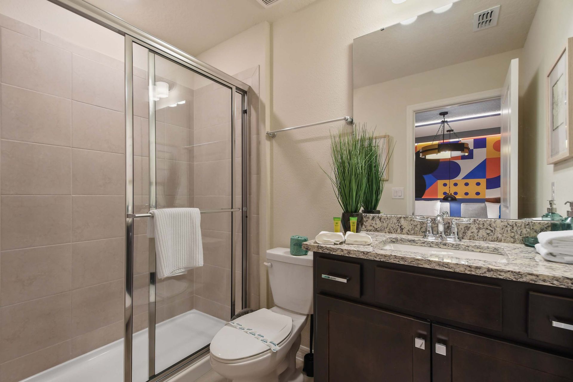 Bright bathroom with granite double vanity and walk-in shower.
