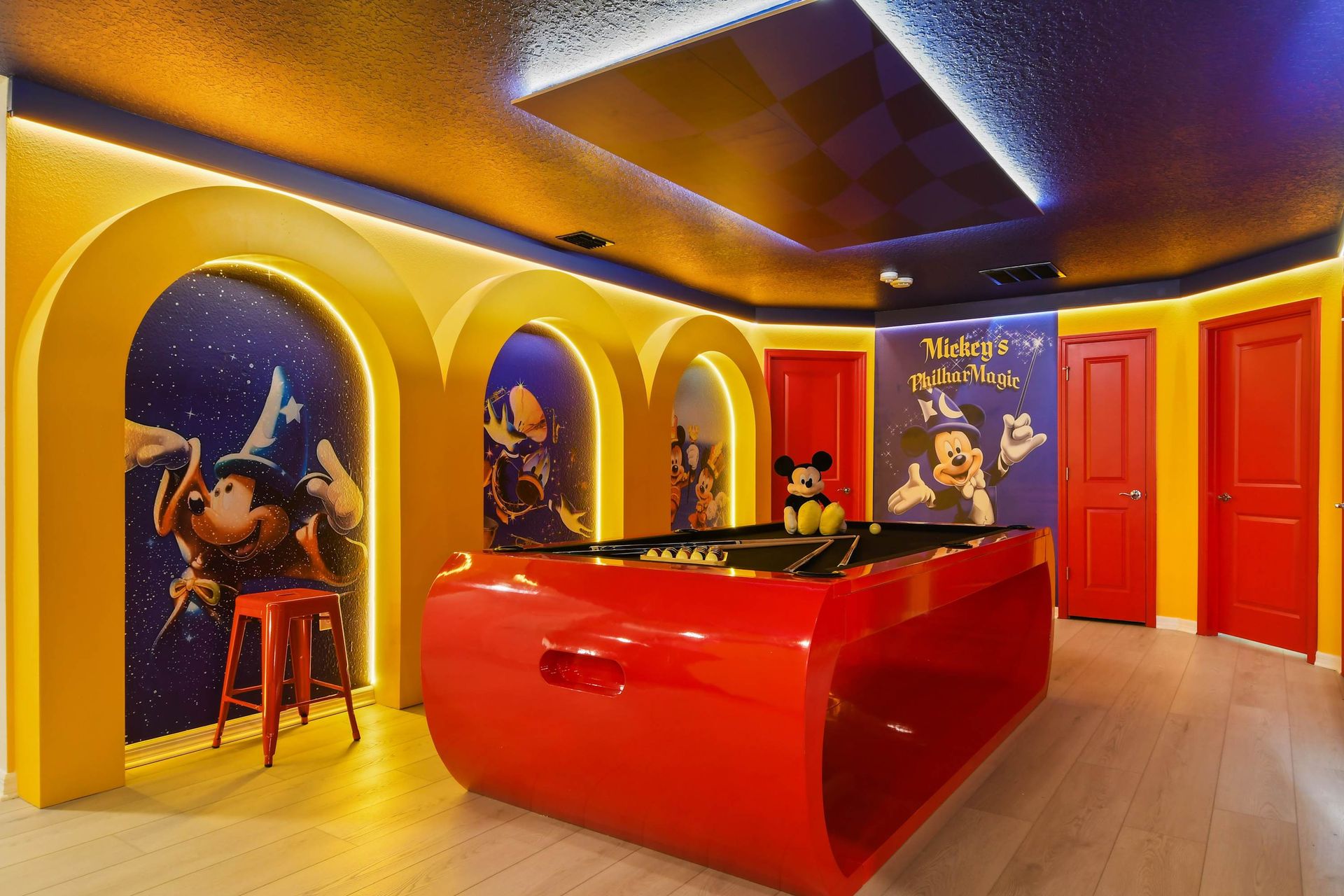 Enjoy a pool table in this Mickey Mouse - inspired game room. Bold colors and whimsical touches create the perfect spot for family fun and entertainment.