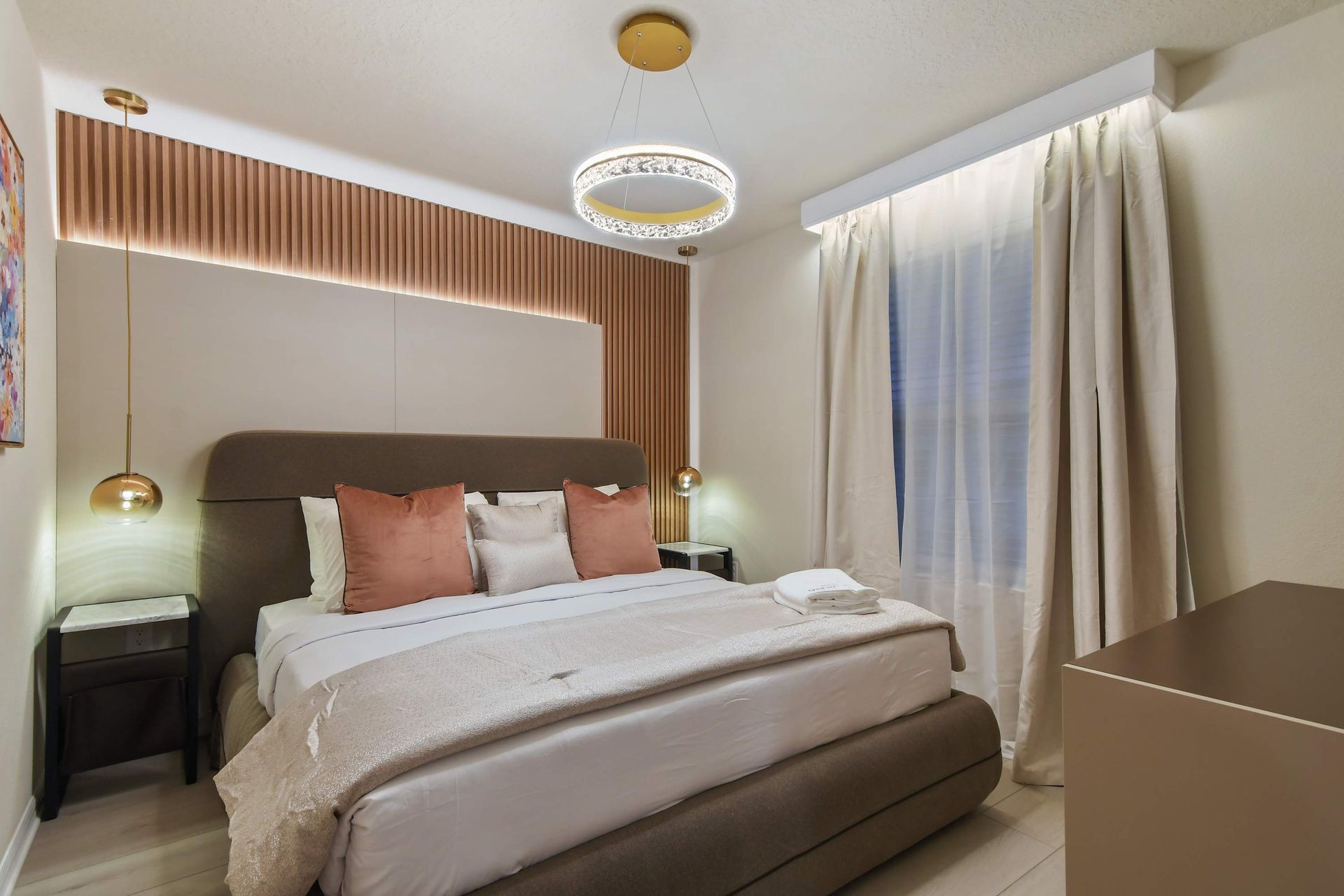 Cozy bedroom with modern lighting, soft hues, and warm accents.