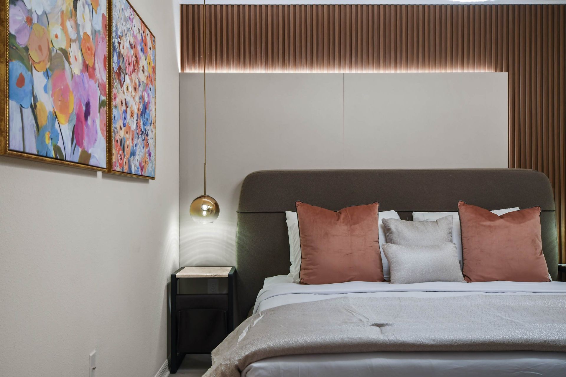 Cozy bedroom with modern lighting, soft hues, and warm accents.