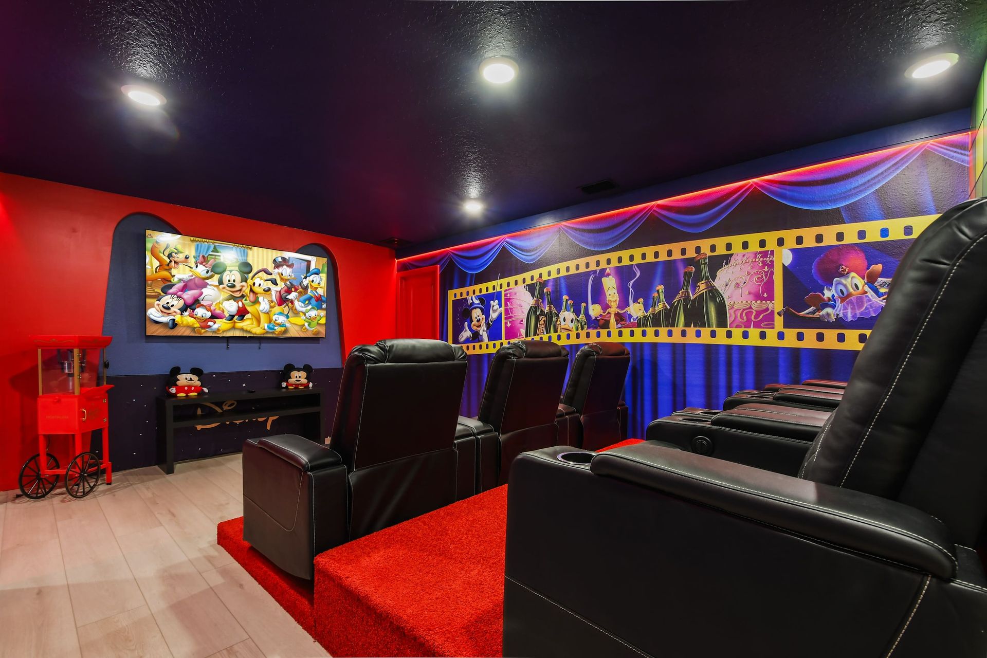 Enjoy cinematic experiences in your own private theater, featuring comfortable recliner seats, a large screen, and vibrant Disney - themed decor.