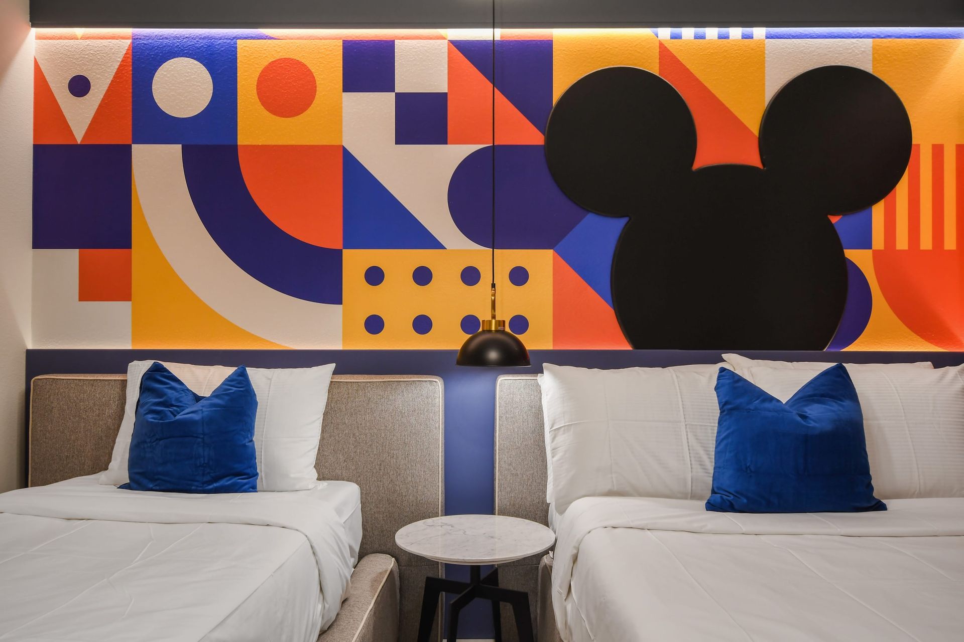 Bright Mickey-inspired room with twin beds and bold modern art.