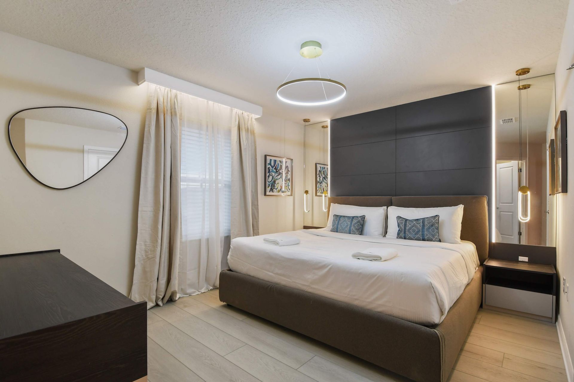 Modern bedroom with stylish lighting, cozy king bed, and charm