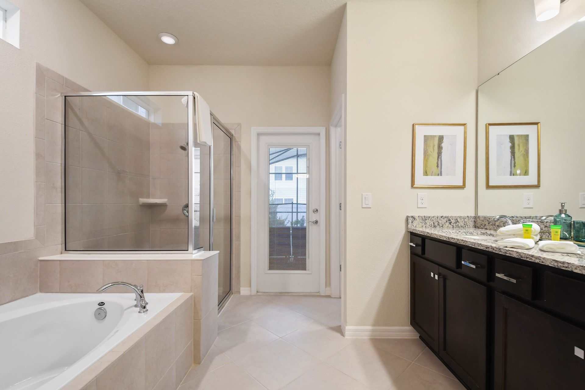 Spacious bathroom with dual sinks, modern lighting, and privacy!
