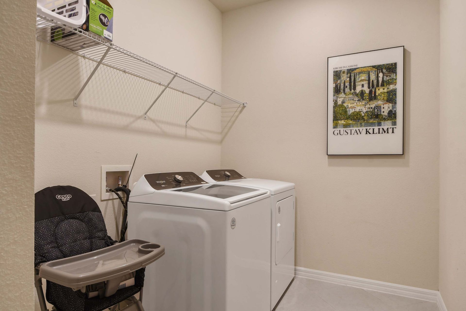 Convenient laundry space with washer, dryer, and shelving.