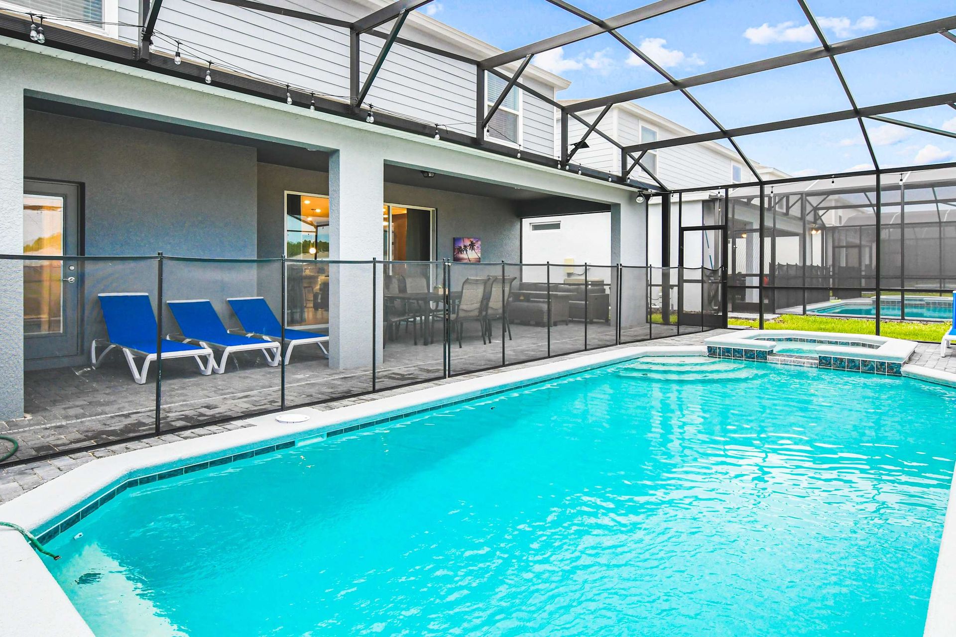 Private screened pool with spa, sun loungers, and covered patio for relaxation.