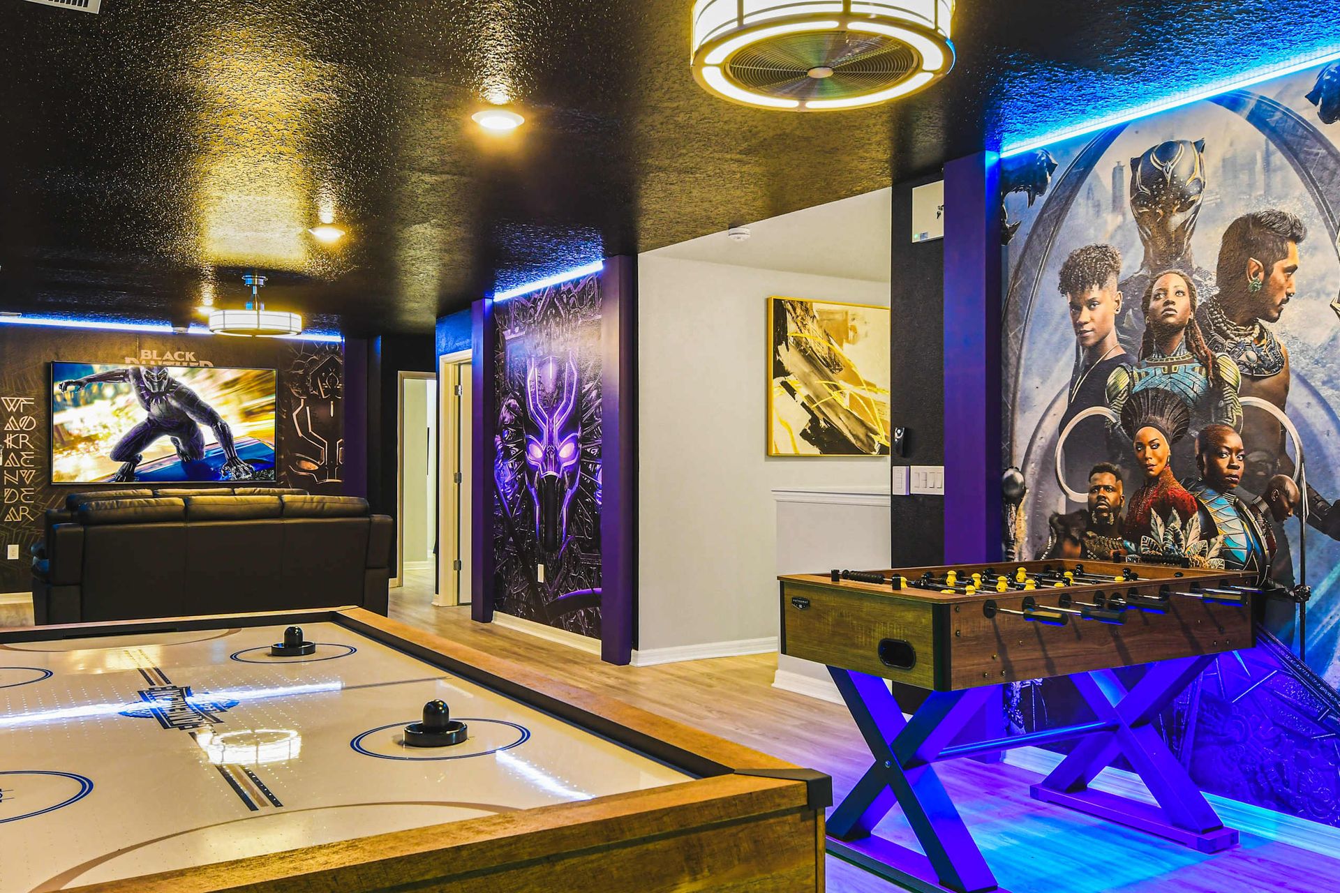 Hero-themed loft with air hockey, foosball, movie lounge, and striking murals.