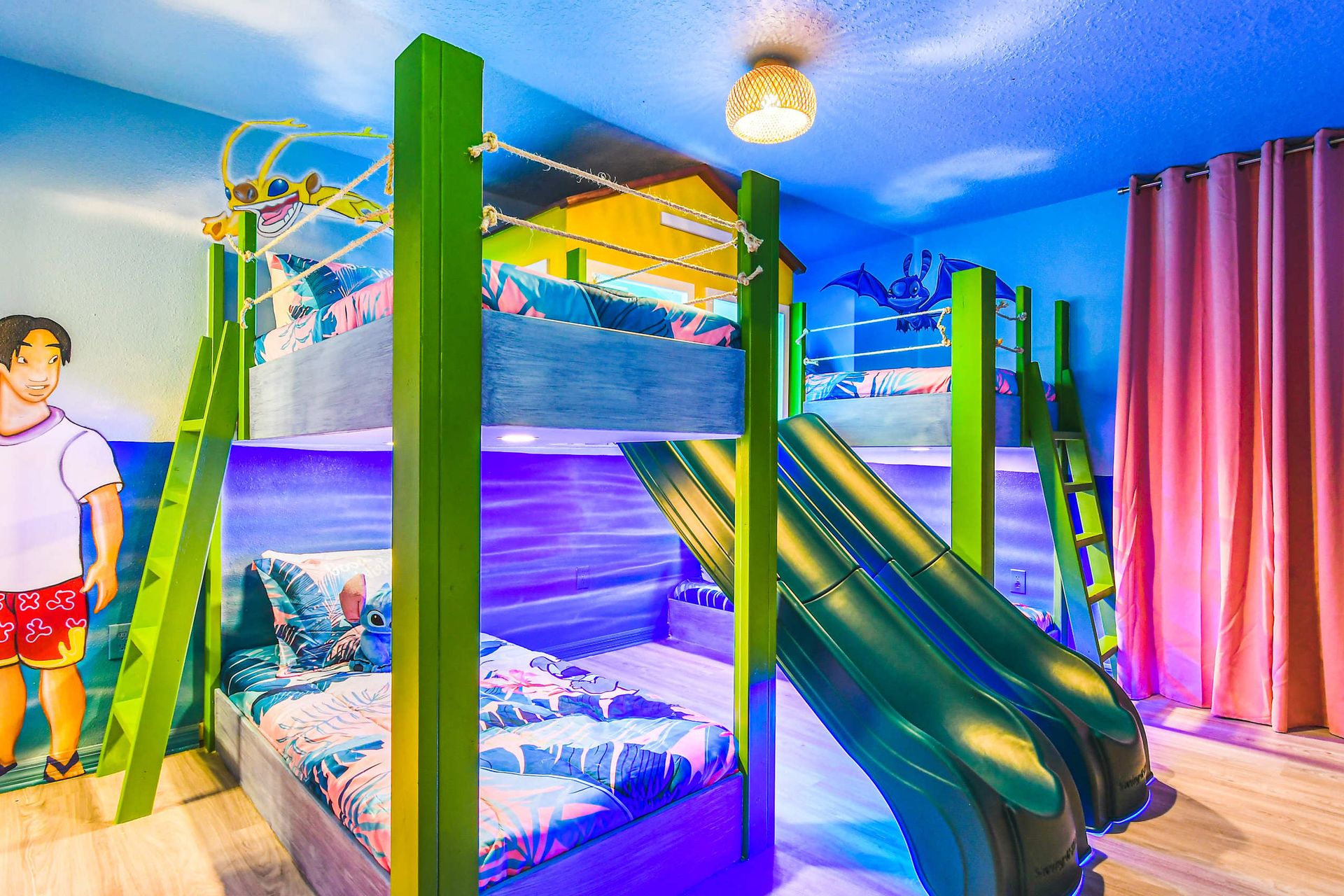 Tropical-themed kids’ room with double slides, bunk beds, and island vibes.