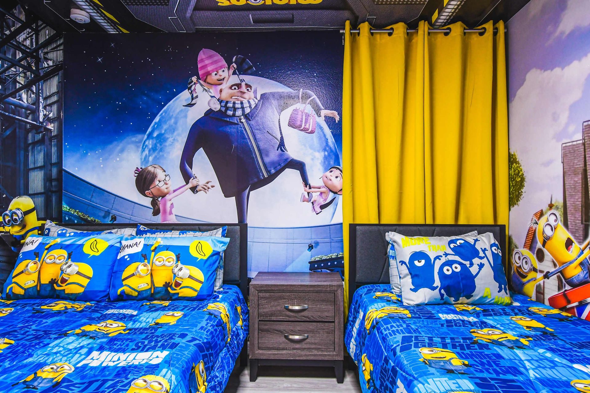 Playful Minion-themed bedroom with twin beds, bold murals, and bright yellow accents.