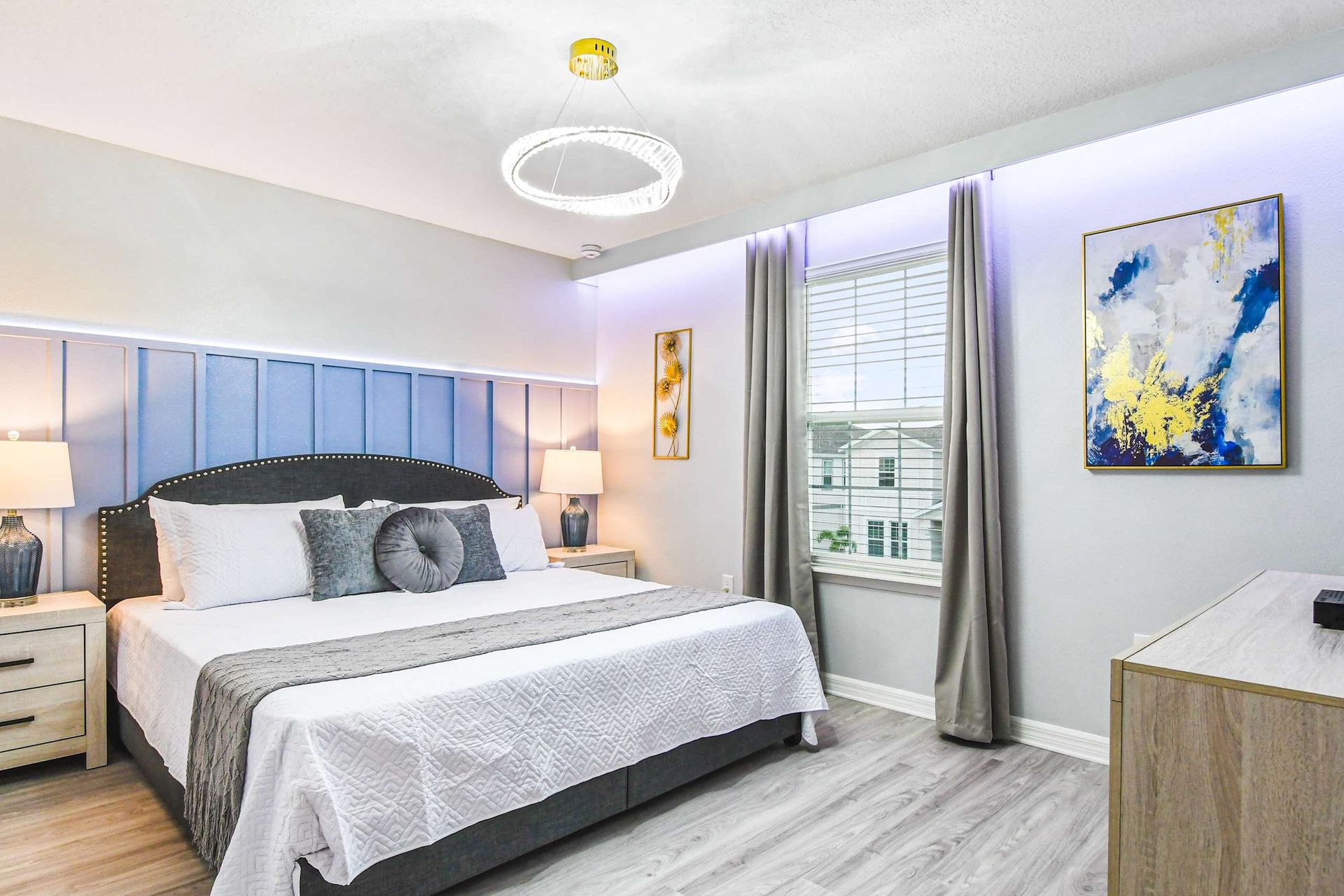 Tranquil bedroom retreat with king bed, soft blue accents, and modern lighting.