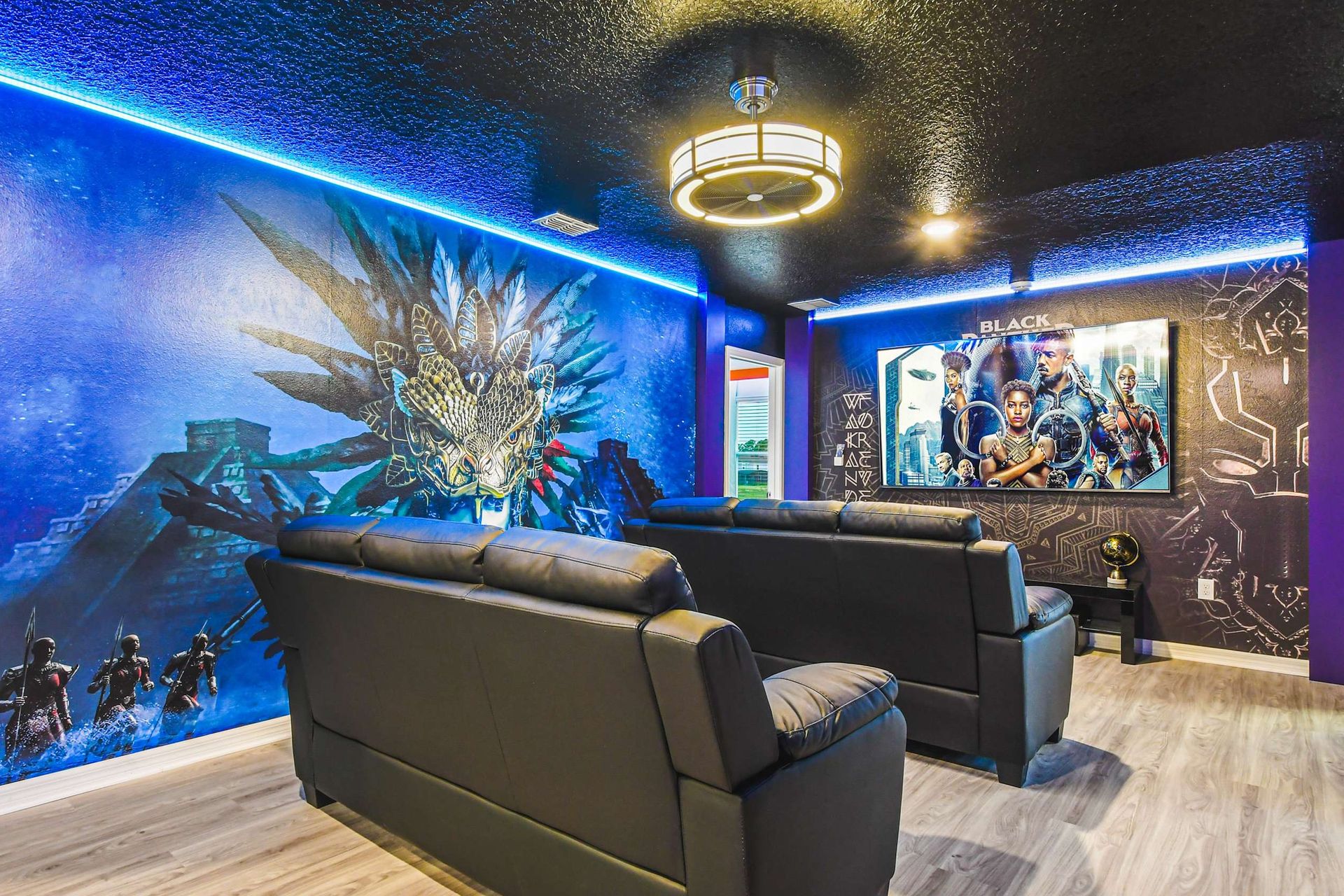 Vibrant home theater with epic superhero murals, LED lighting, and plush seating.