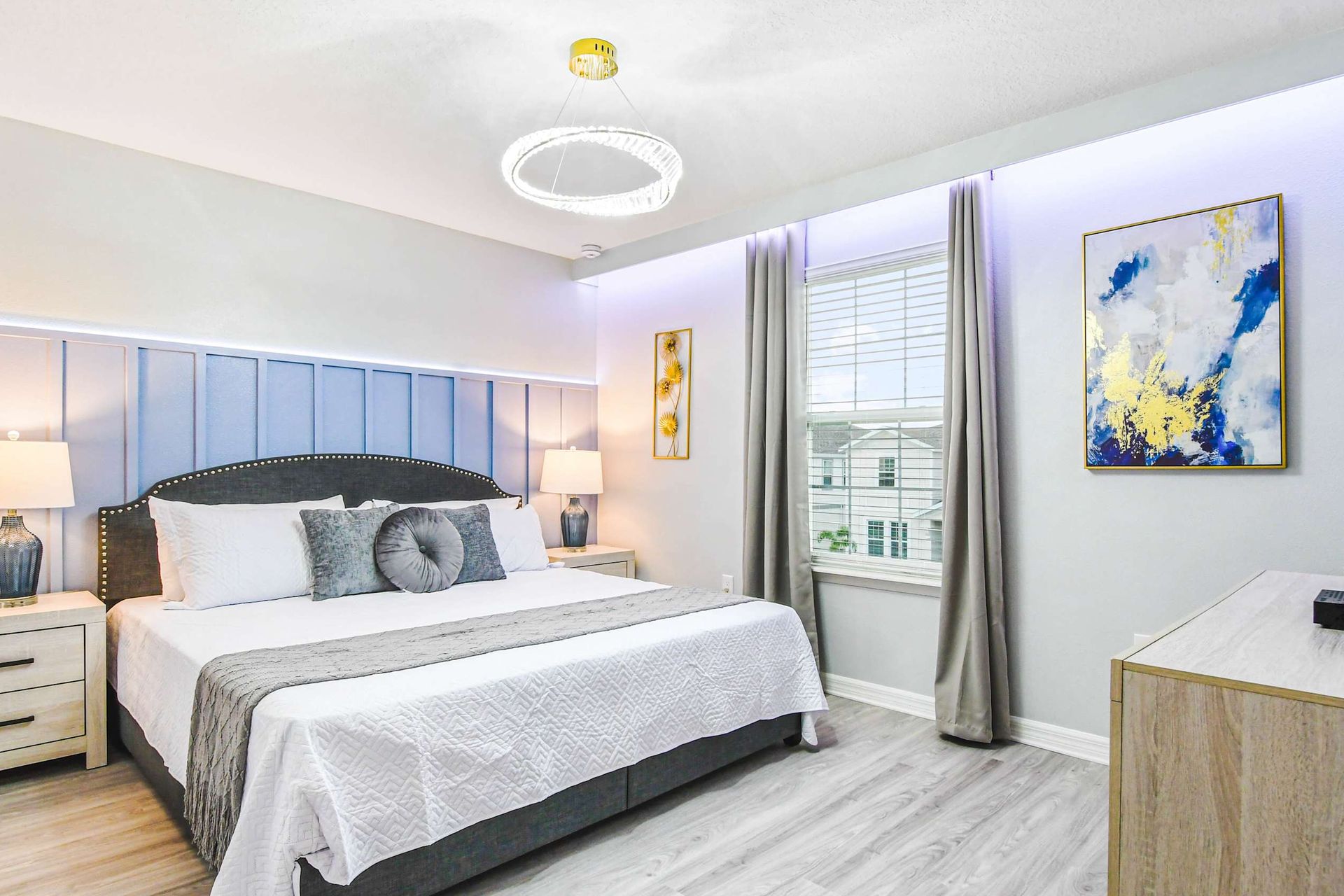 Tranquil bedroom retreat with king bed, soft blue accents, and modern lighting.