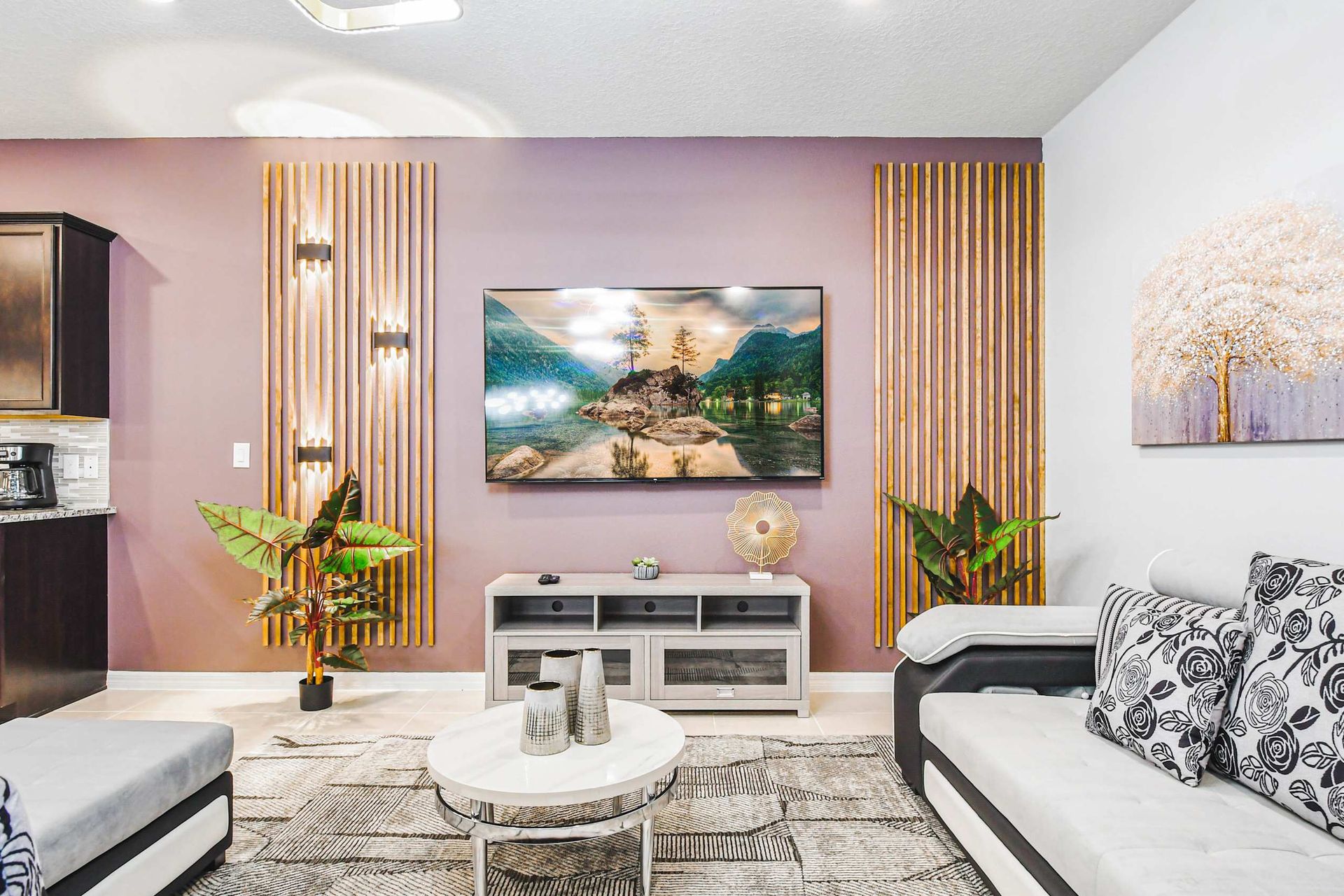 Chic living area with modern decor, cozy seating, and a large smart TV centerpiece.