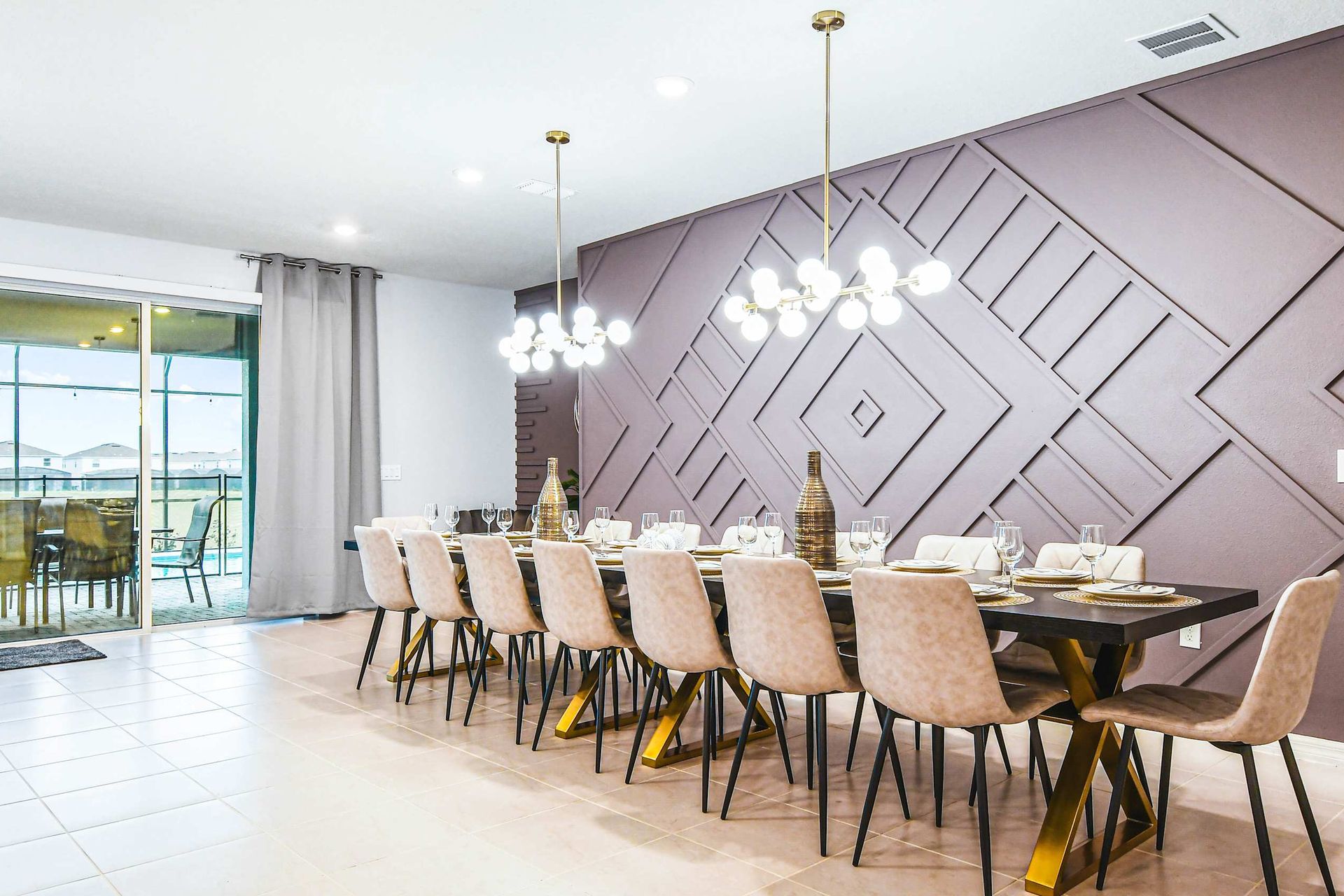 Stylish dining space with bold accent wall, elegant lighting, and seating for 14.