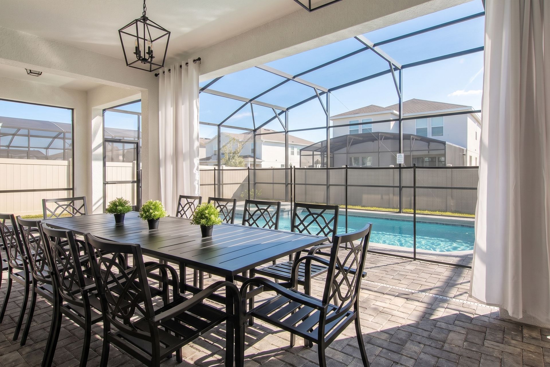Spacious screened patio with elegant dining and a view of the private pool.