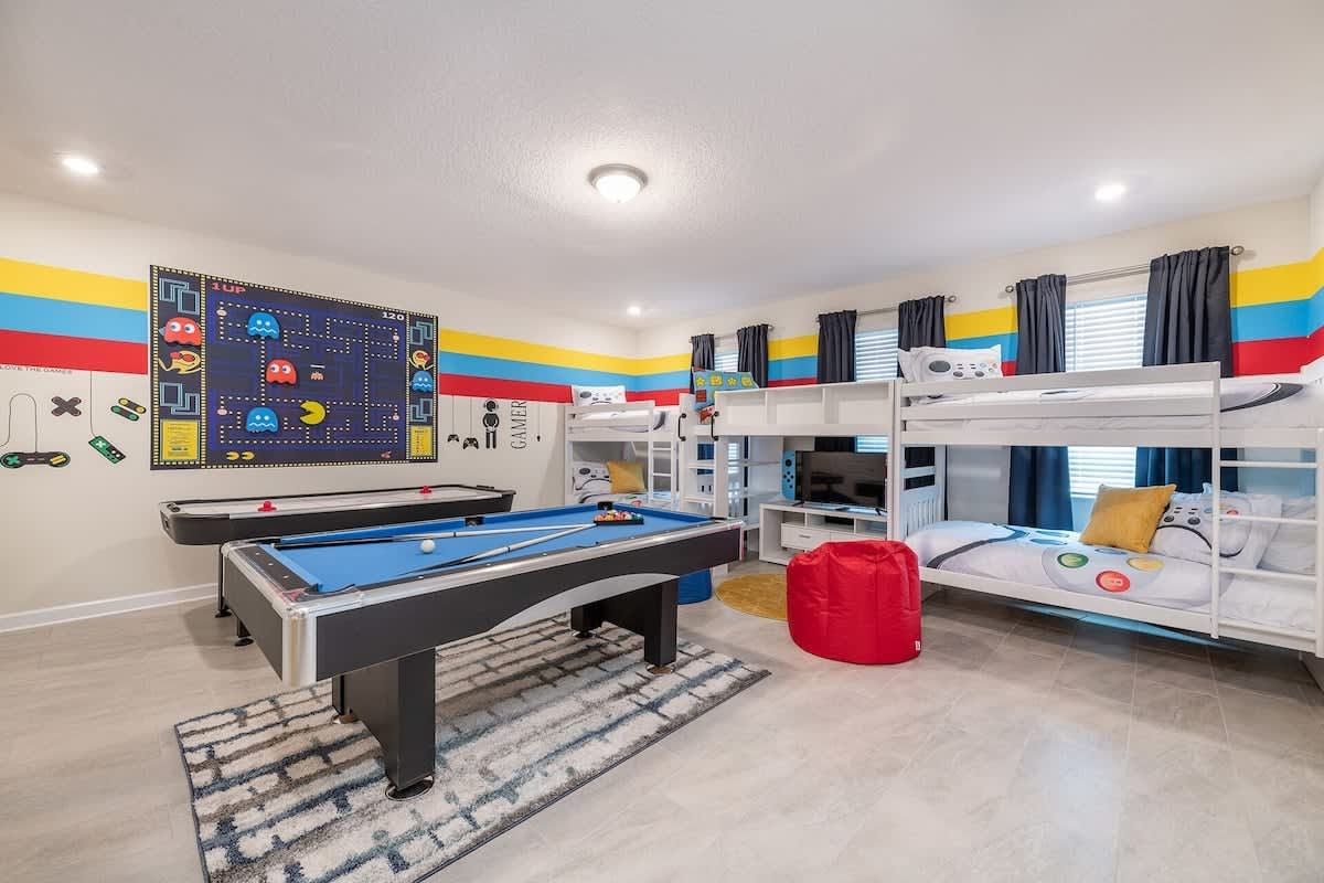 Retro gamer-themed room with bunk beds, pool, air hockey, and bold colors!