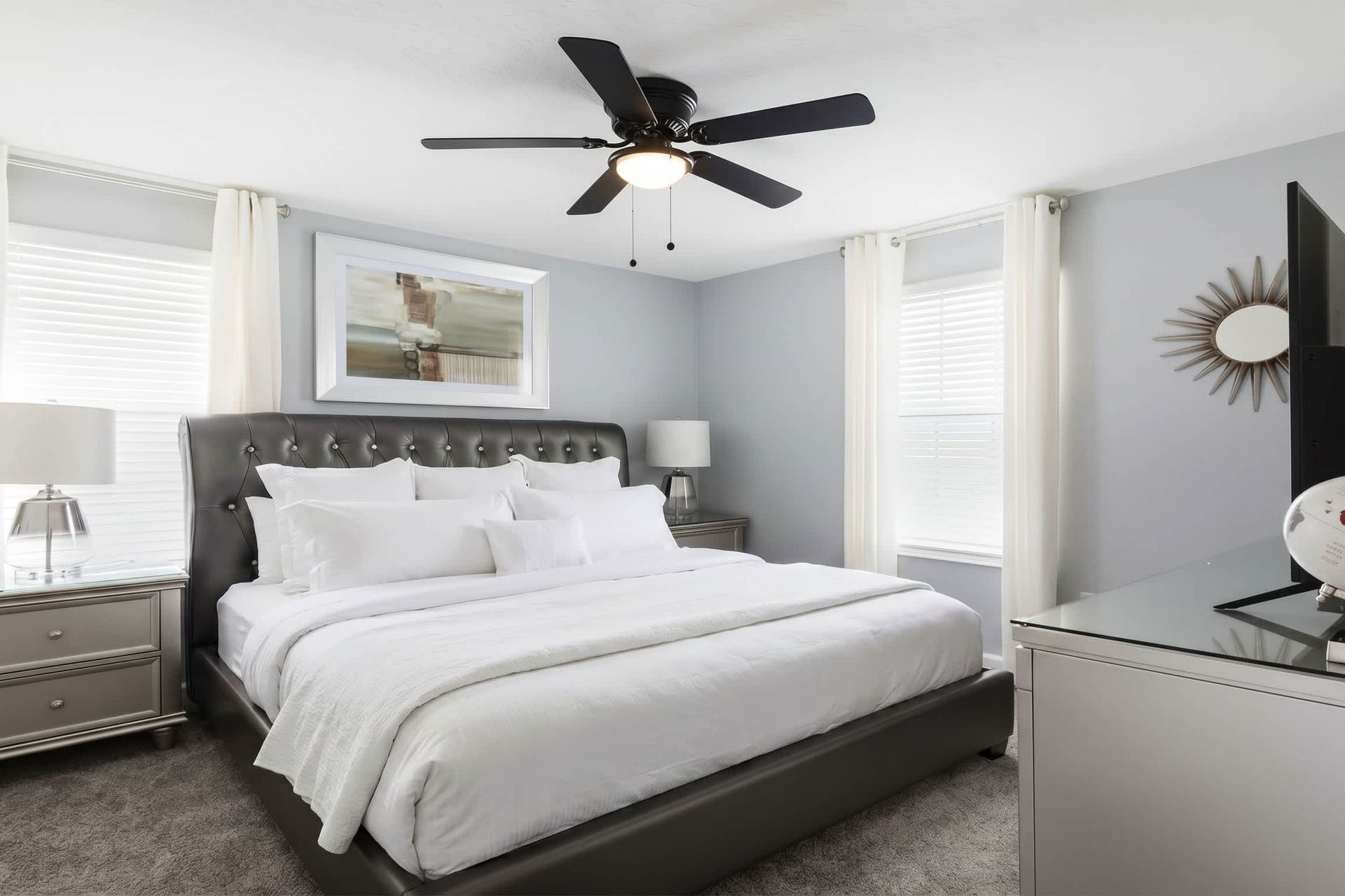 Elegant king bedroom with soft lighting, plush bedding, and modern decor touches.