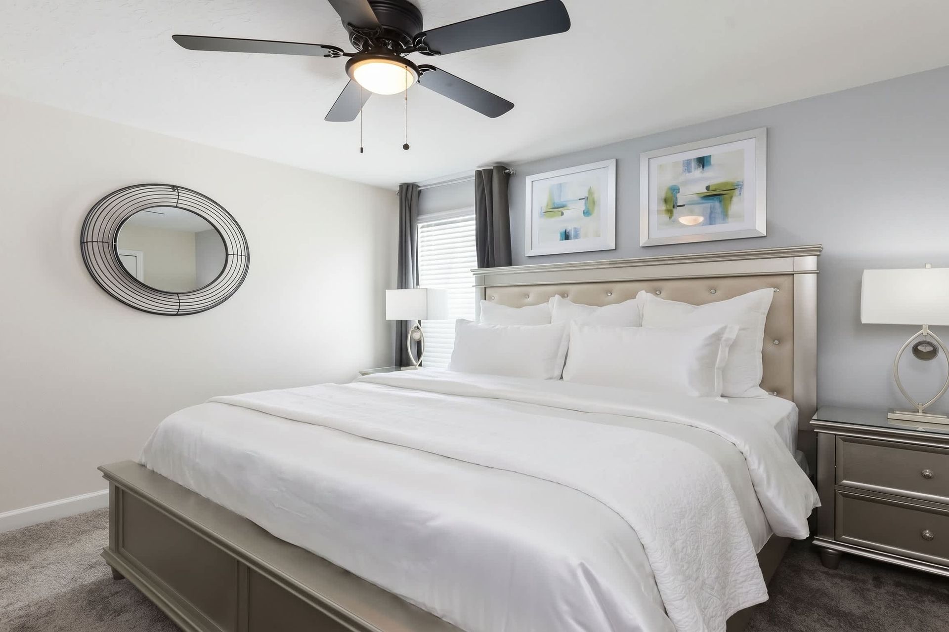 Stylish king bedroom with plush bedding, silver accents, and calming tones.