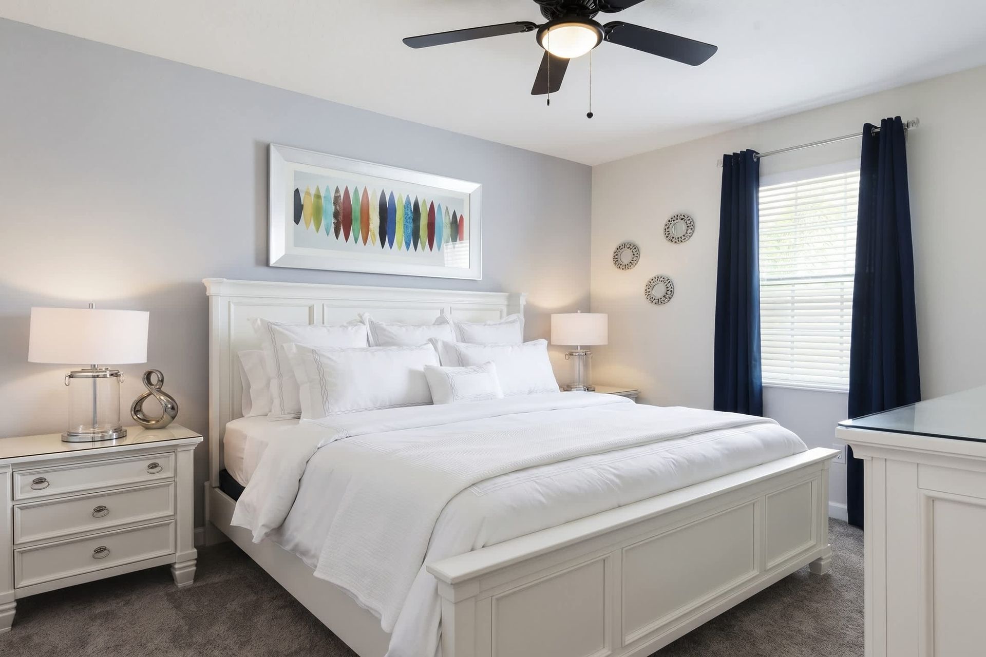 Bright and inviting king bedroom with bold navy accents and modern elegant décor.