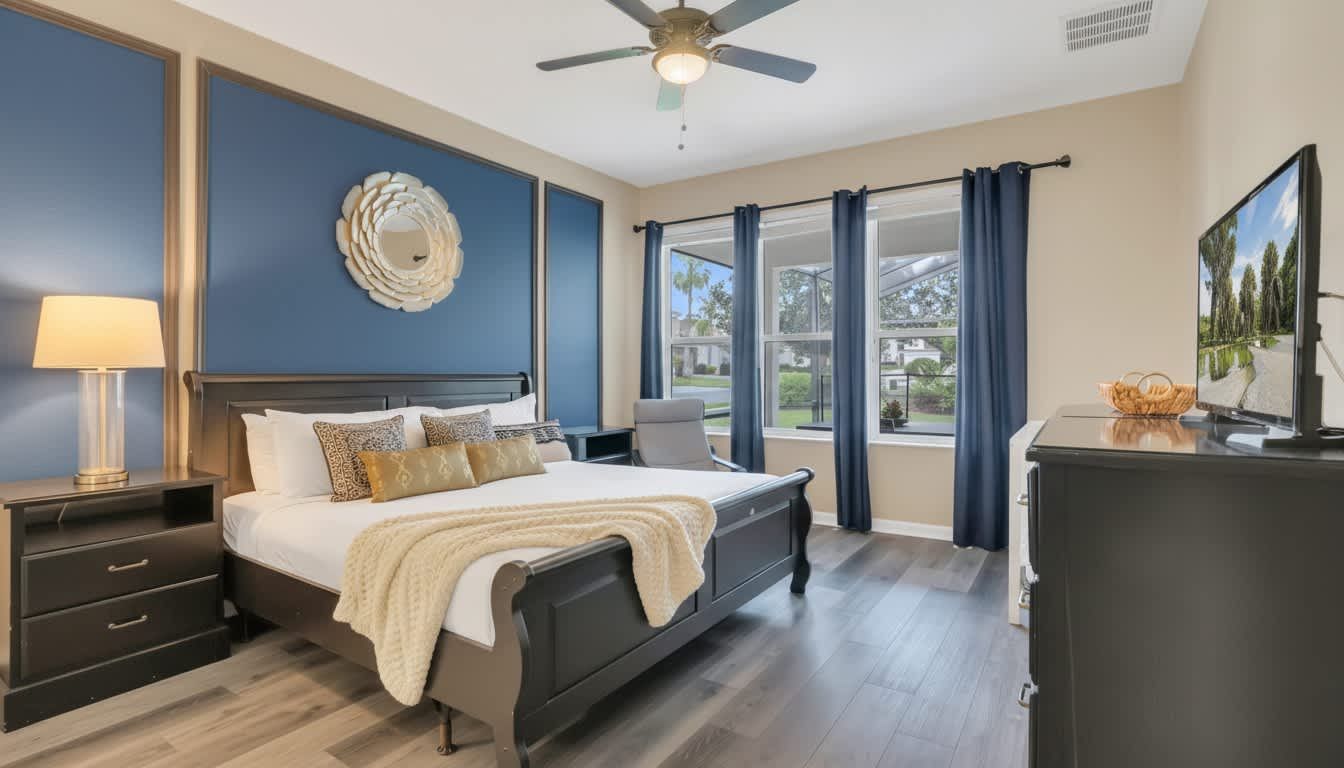 Elegant master suite featuring a bold navy accent wall and sun-drenched modern luxury.