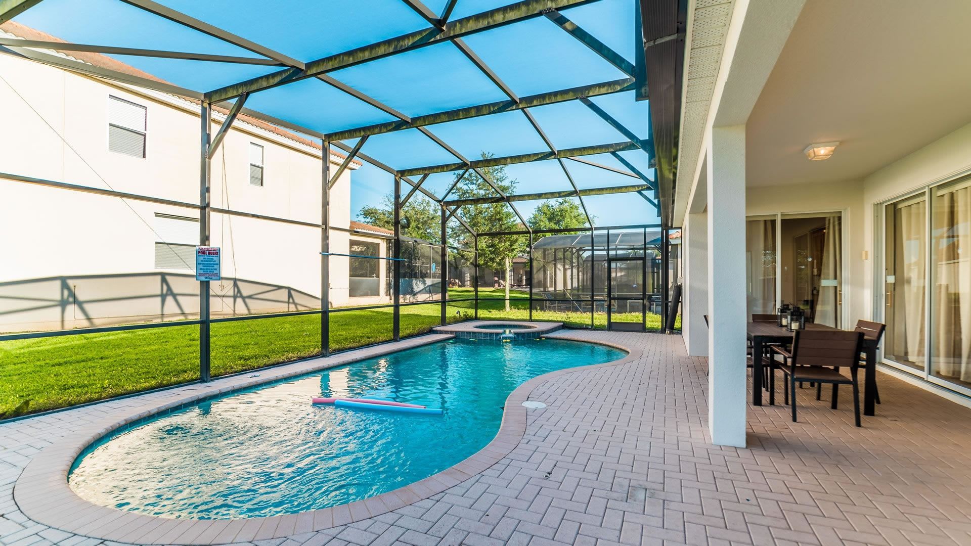 Sun-drenched private oasis featuring a crystal-clear pool and stylish poolside dining area.