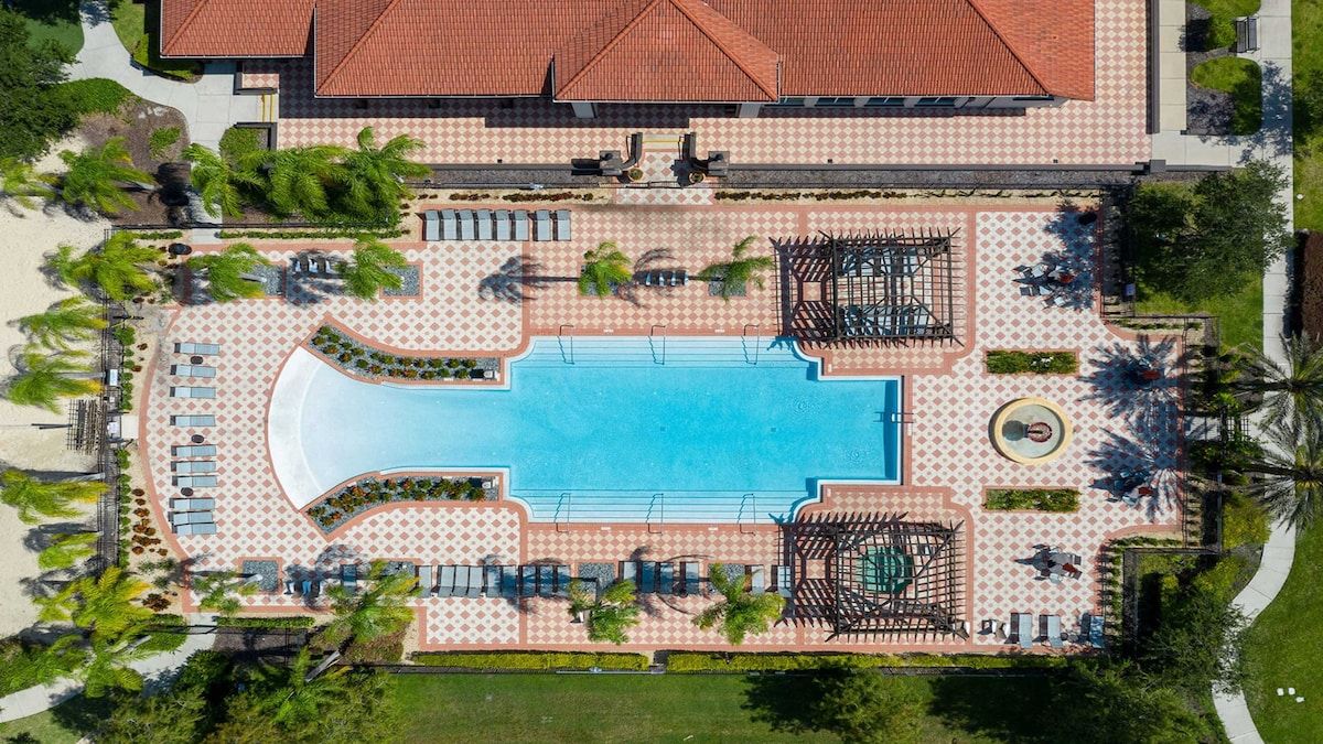 Resort-style pool with lounge areas, pergolas, and lush scenery!