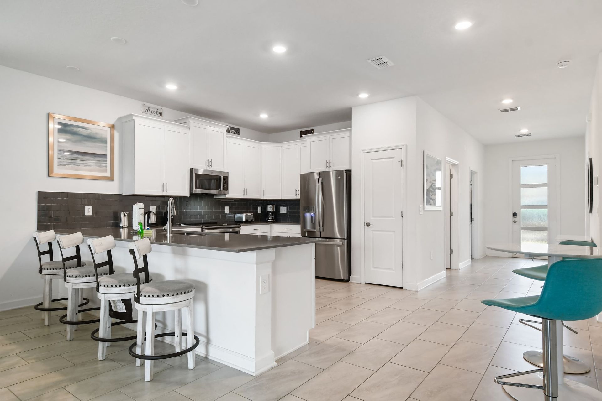 Modern kitchen with sleek appliances, spacious island seating, and bright open layout