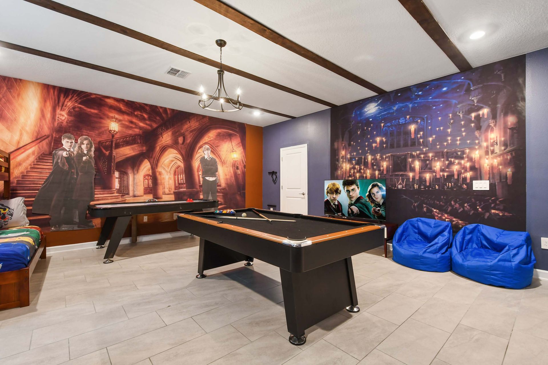 Wizard-themed game room with pool table, bean bags, and cinematic wall murals.
