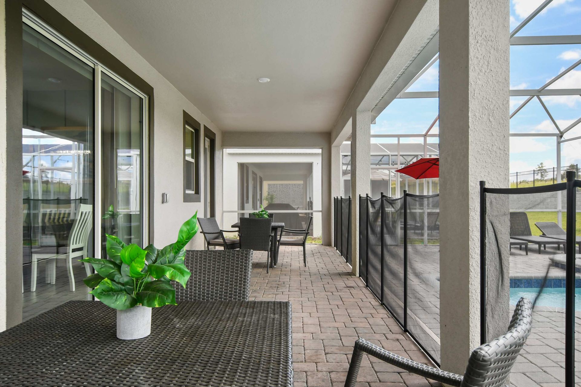 Shaded patio with outdoor dining, pool views, and a secure safety fence.
