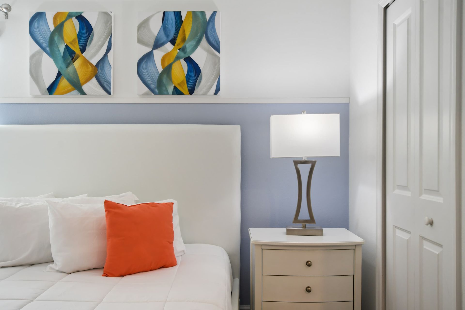 Chic bedroom with a king bed, modern art, bold accents, and cozy comfort.
