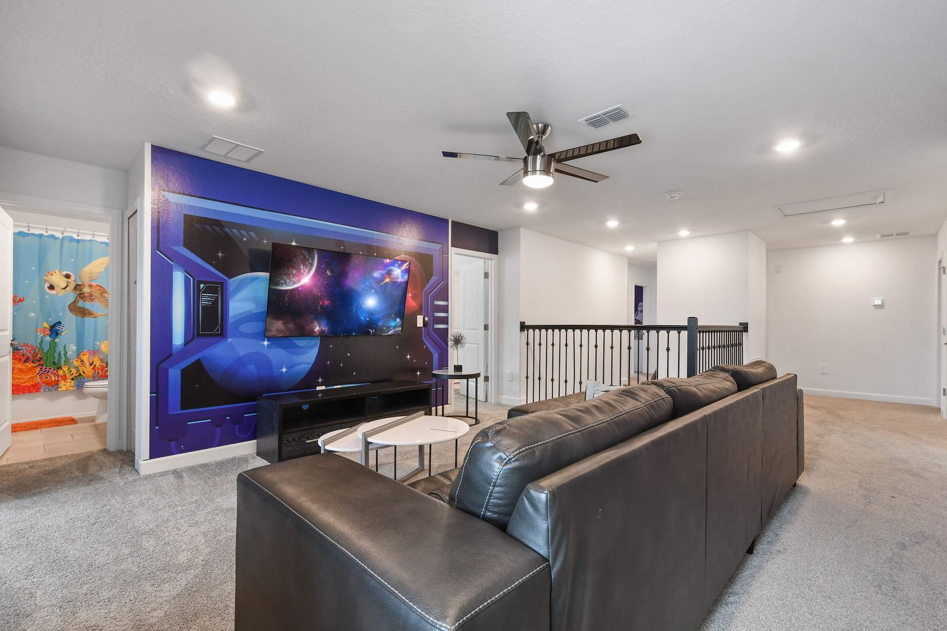 Futuristic loft lounge with galaxy mural, large sectional, and sci-fi vibes throughout.
