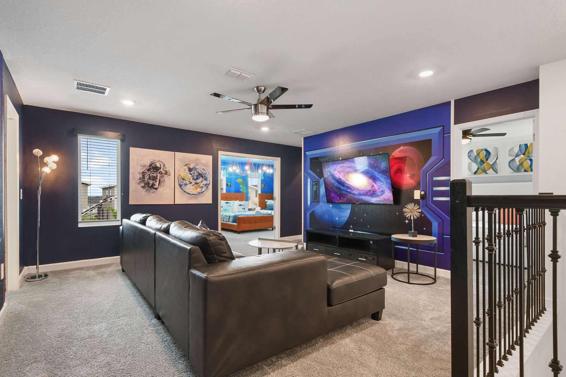 Futuristic loft lounge with galaxy mural, large sectional, and sci-fi vibes throughout.
