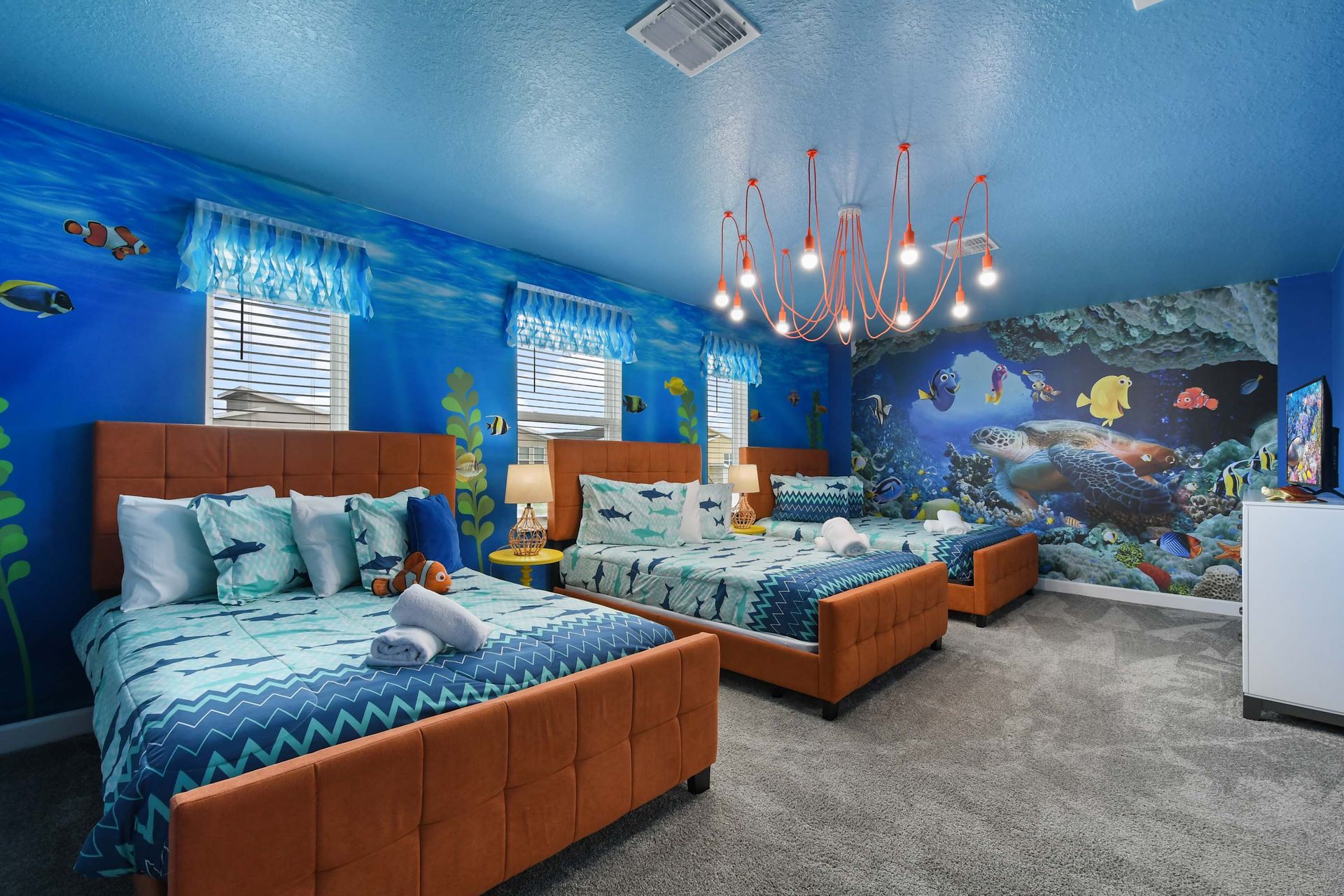 Spacious loft with galaxy wall art, cozy sectional, and a sleek entertainment setup.
