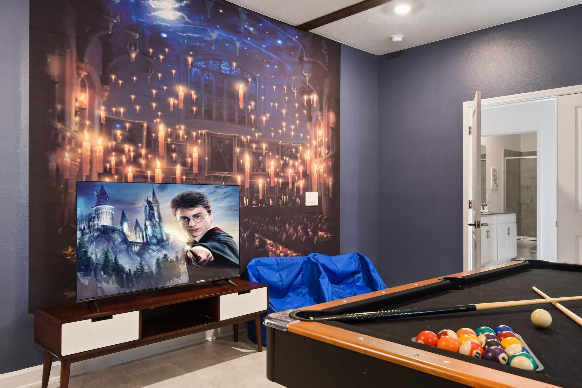 Immersive wizard-themed room with pool table, movie setup, and magical decor.
