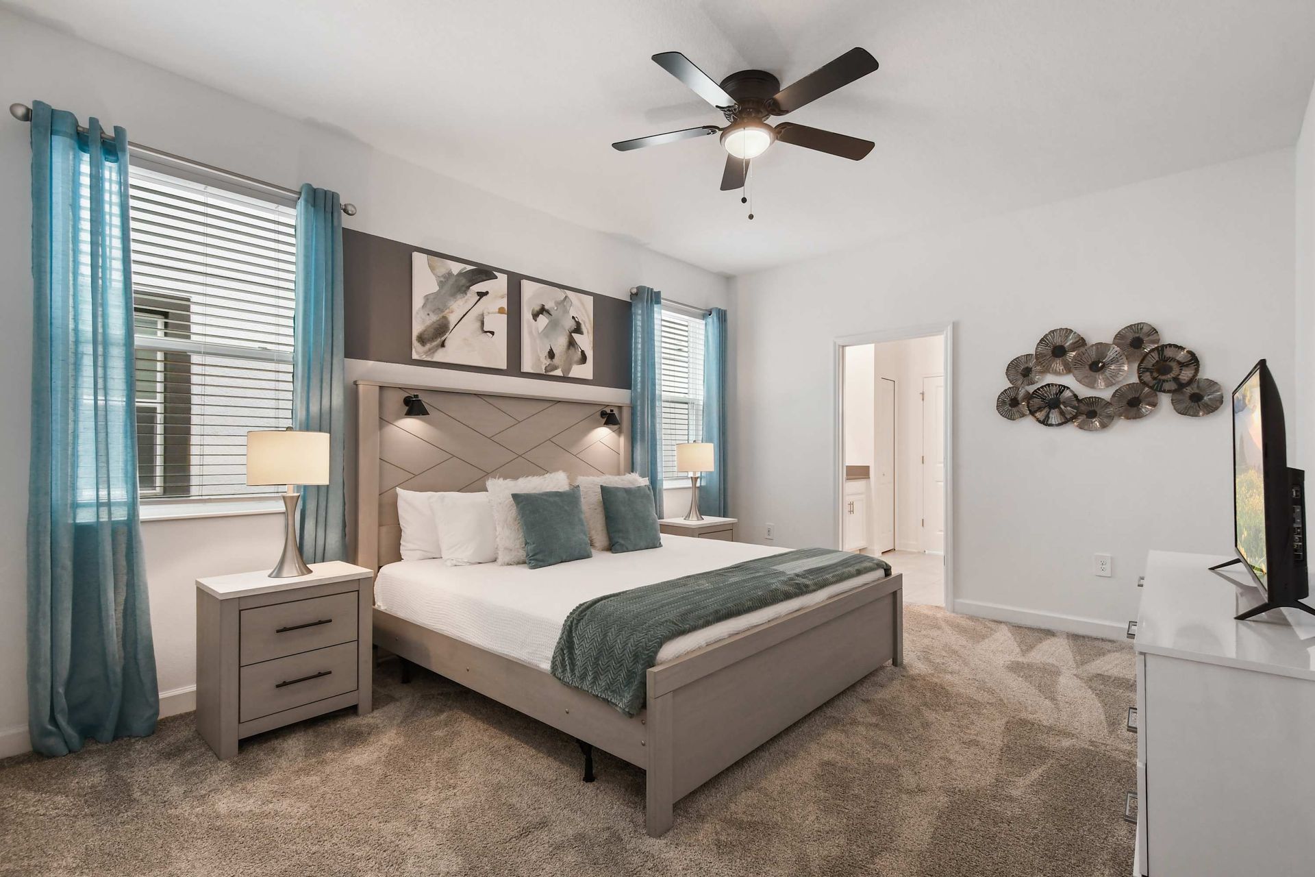 Serene bedroom with king bed, ensuite bath, cozy carpet, and calming accents.