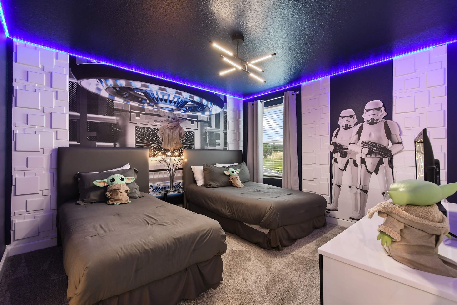 Galactic-themed kids’ room with twin beds, LED lights, and space adventure decor.
