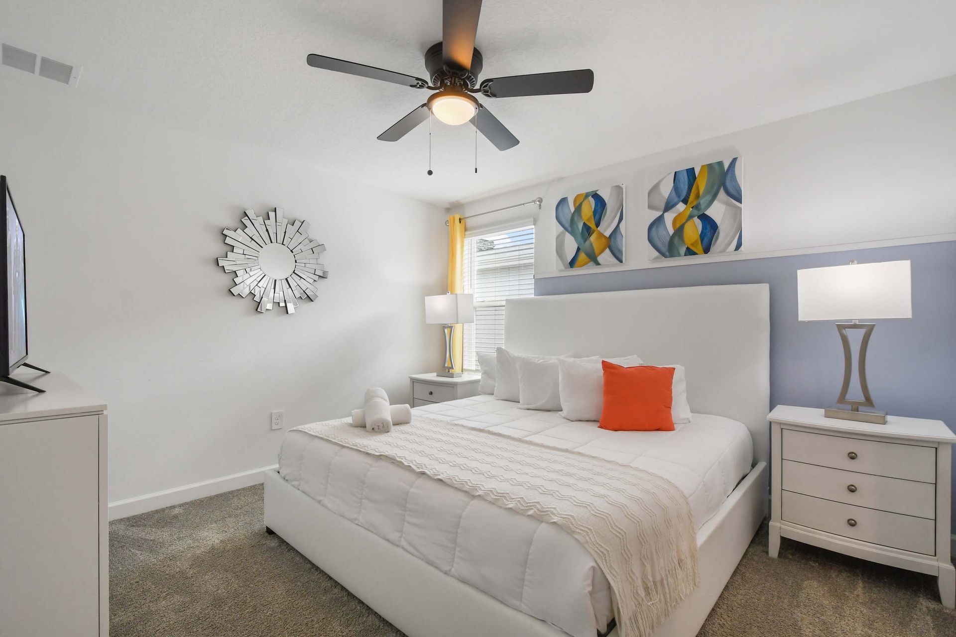 Chic bedroom with a king bed, modern art, bold accents, and cozy comfort.
