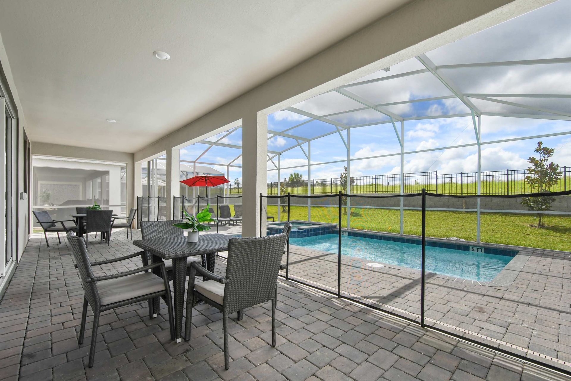 Covered patio with dining area, screened-in pool, and fenced safety for family fun.
