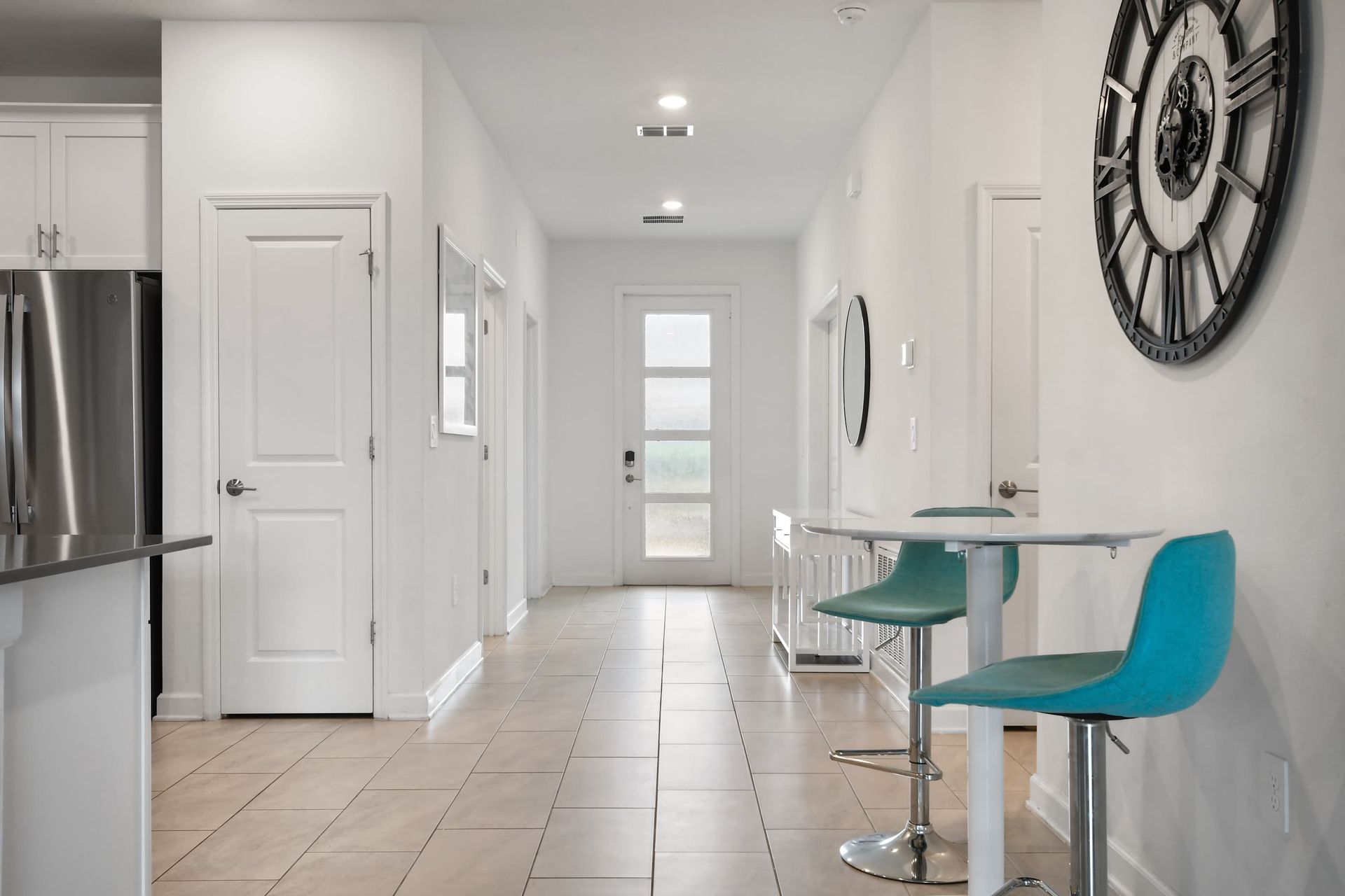 Bright and modern entryway with stylish seating, wall art, and clean tile floors.
