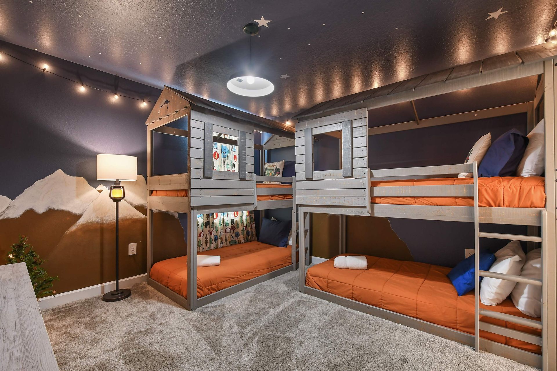 Cozy bunk room with mountain theme, twinkle lights, and playful cabin-style beds
